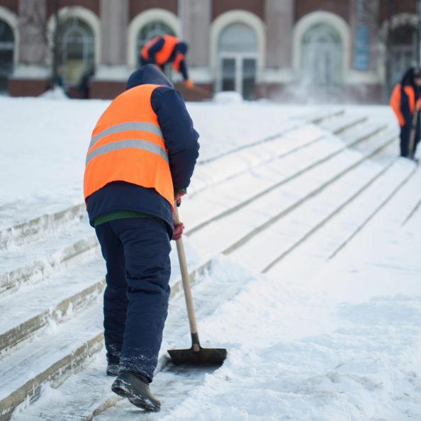 Workers sweep snow from road in winter, Cleaning road from snow storm.